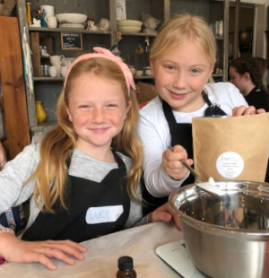 Two tween girls enjoying making natural skincare at a Sage Cosmetic Coaching school holiday workshop